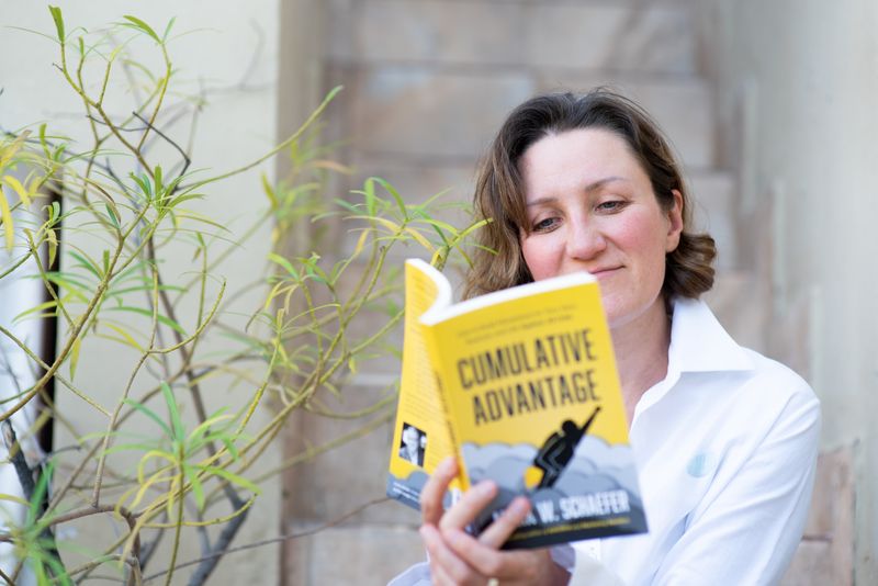 young professional woman reading a book in her industry