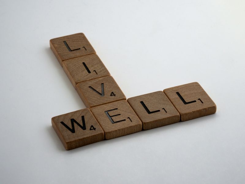 Scrabble tiles that spell out the words 'Live' and 'Well'