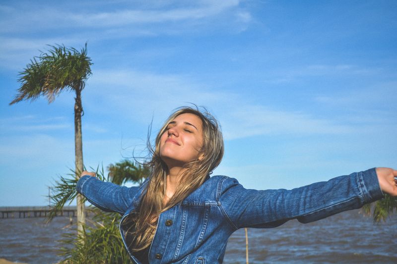 Woman with arms open smiling.