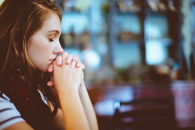 A young woman closing her eyes to focus