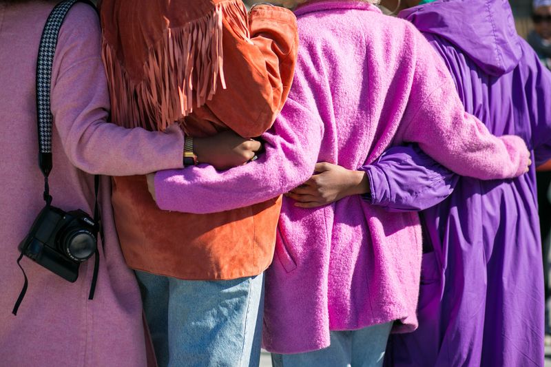 four people seen from the back, all of them embrassing each other