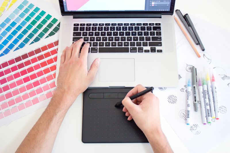 Laptop with colour palette and markers on a table