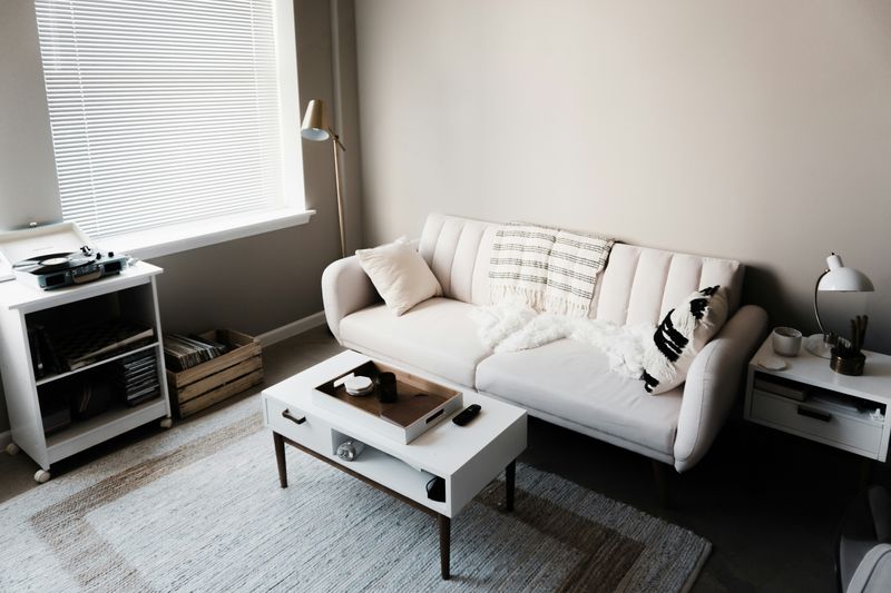 Photo of an apartment with neutral colors (couch, coffee table, end tables, etc)