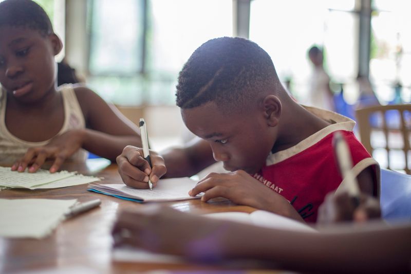 A boy writing with a pen.