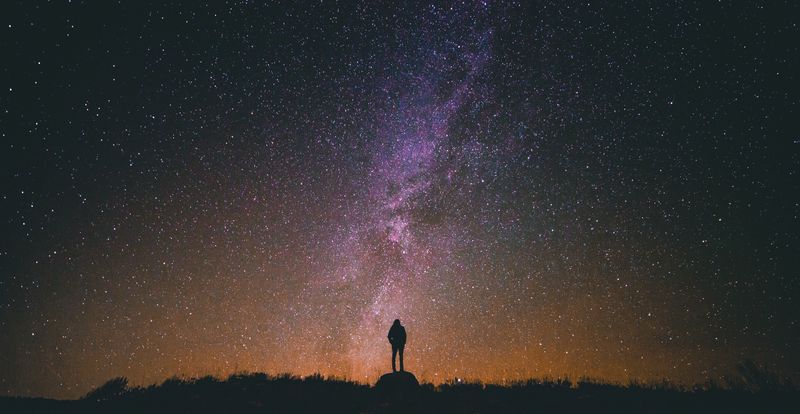 Far away shot of person stargazing