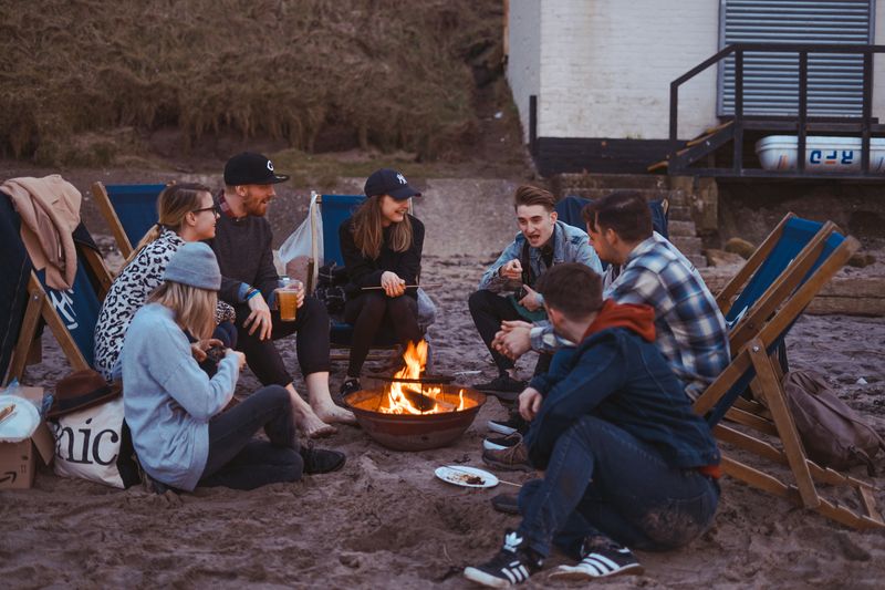 A group of friends sitting around a campfire.