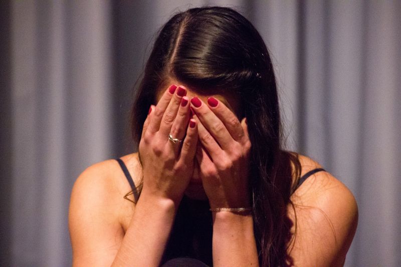 Woman covering her face with two hands