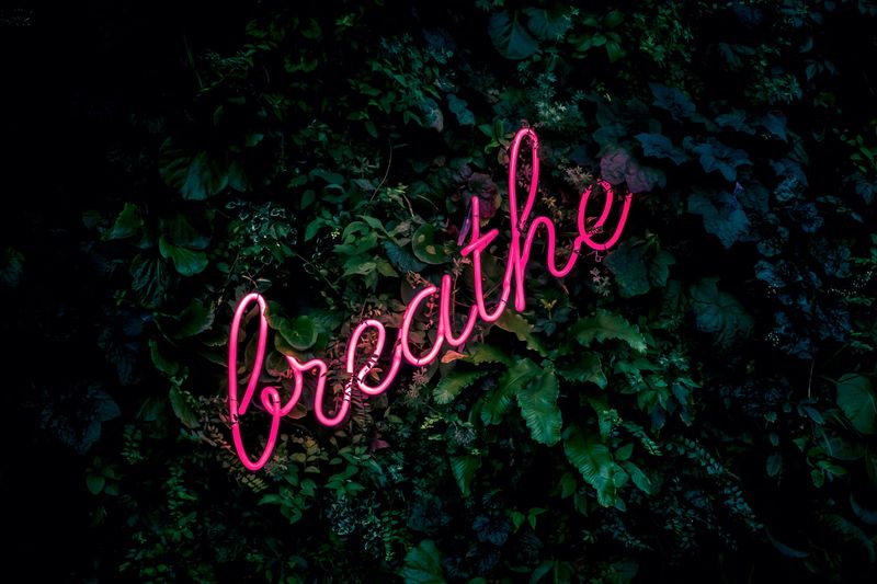 A neon sign that says 'breathe'