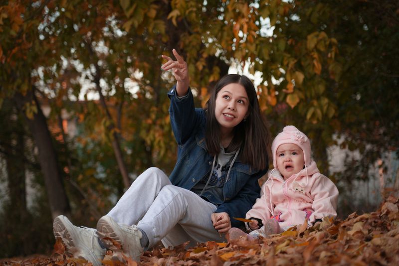 A daycare educator helps a crying child.