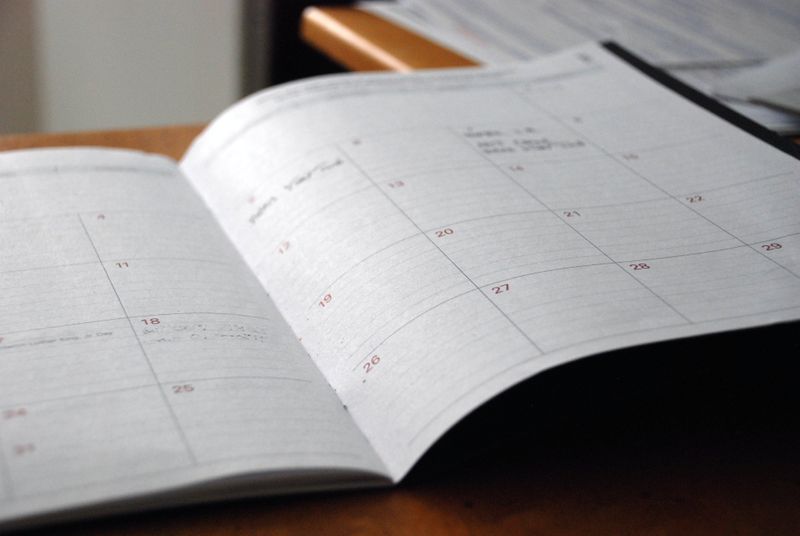 A paper calendar laying open on a desk.