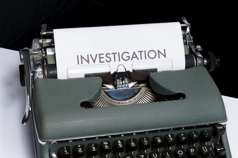 Typewriter with a white paper in it that says INVESTIGATION