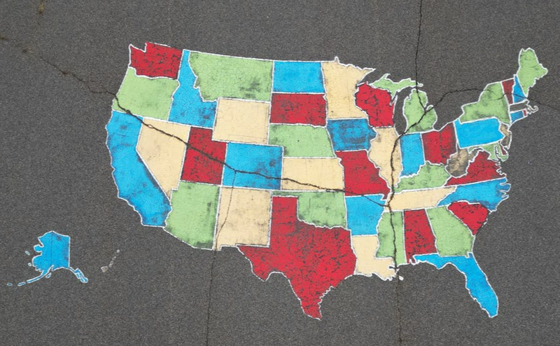 A map of  US states drawn in colorful chalk on a pavement.