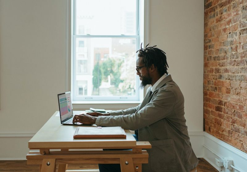 A man working on a laptop from an apartment.