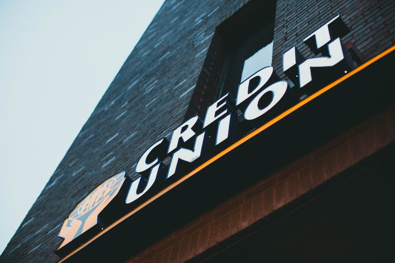 Sign that says 'Credit Union' outside brick building.