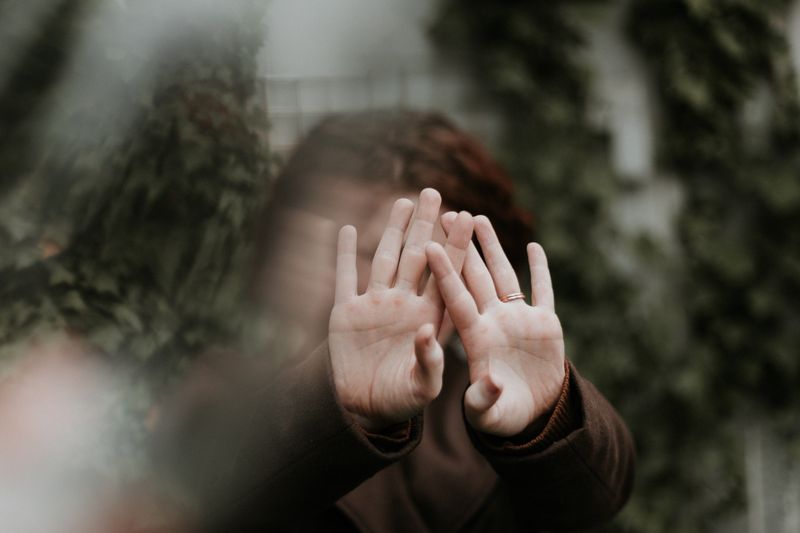 A person covering their face with their hands.