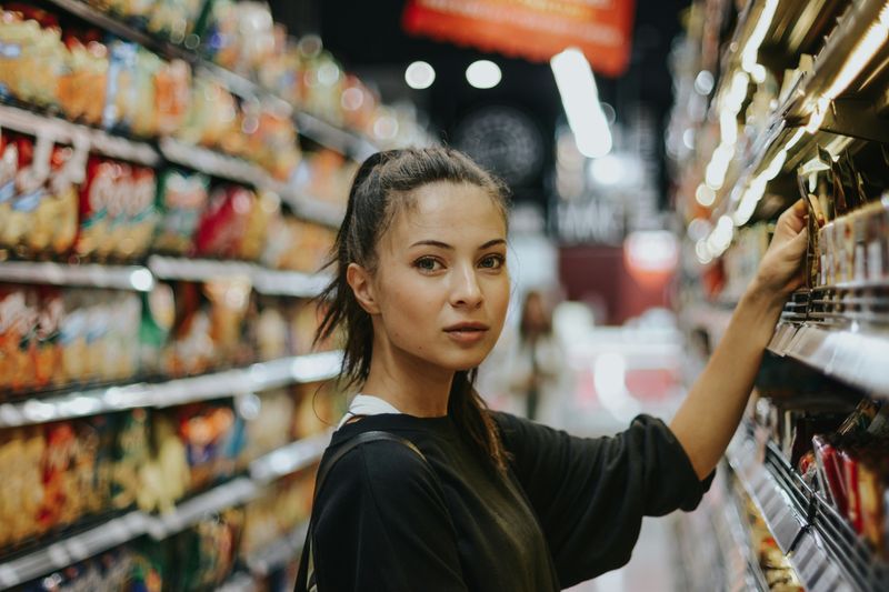 A woman at a grocery store picking out food.