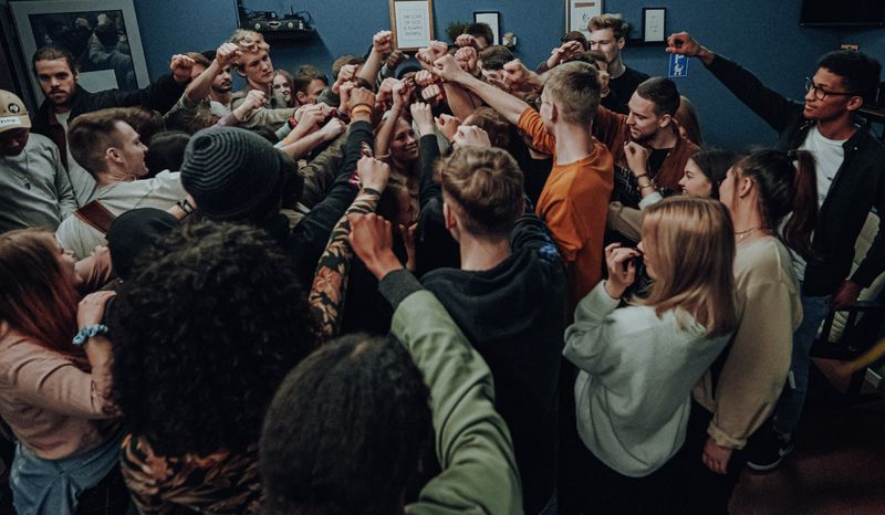 A group of people holding their hands up together.