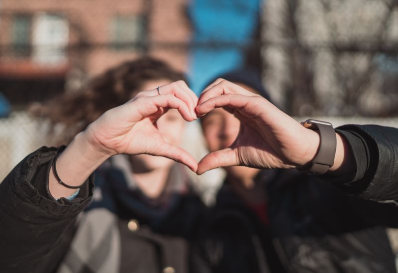 Friends making a heart with their hands.