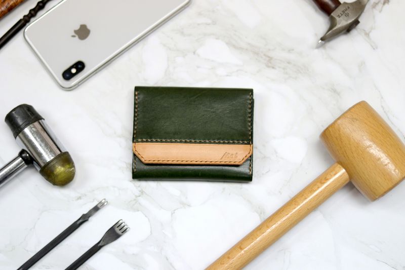 Flat lay of wooden mallet, black rubber mallet, pronged chisel, flat chisel, hammer, iphone on marble surface.