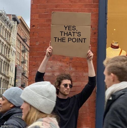 Guy holding a cardboard sign that says 'Yes, that's the point.'