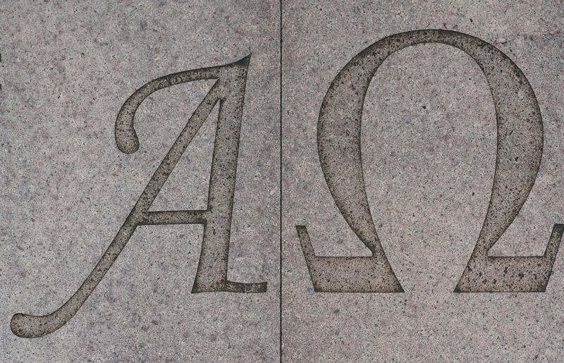 The greek letters alpha and omega on a stone wall.