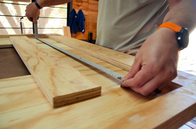 A carpenter measures a piece of wood