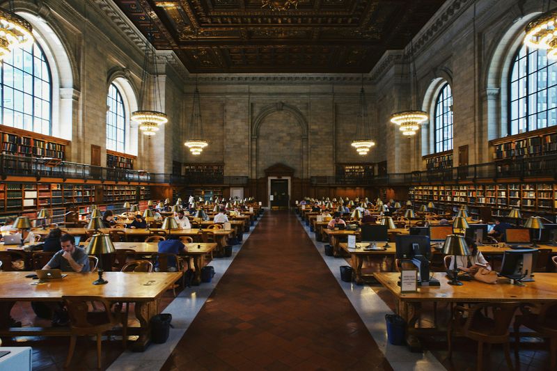 A grand library filled with people working.