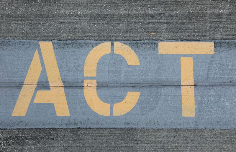 Street art with the word "act" stencilled on it with a neat font and yellow paint.
