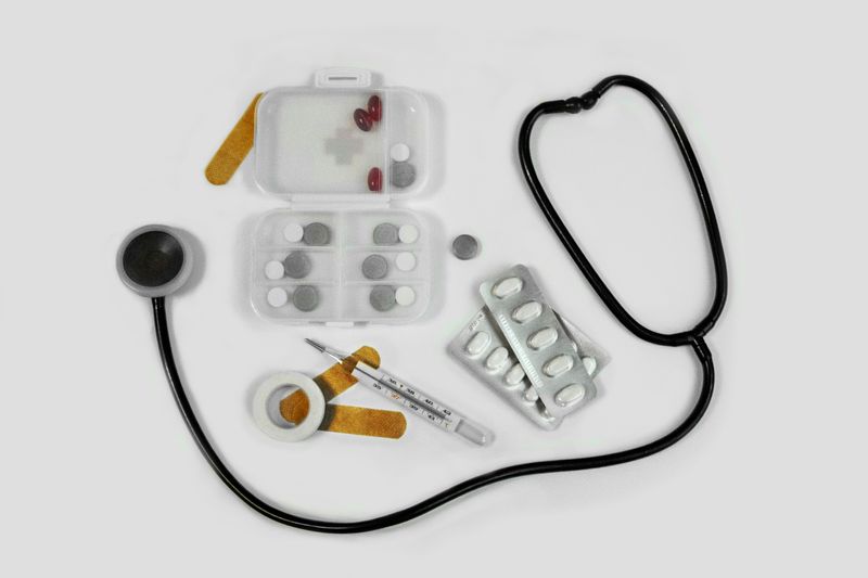Medical tools including a stethoscope, pill organizer, thermometer, and bandages.