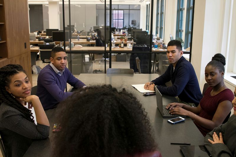 A group of people in a meeting room interviewing a candidate.