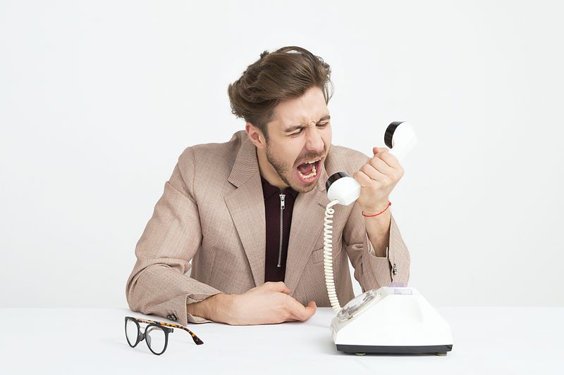 A man screaming into telephone.