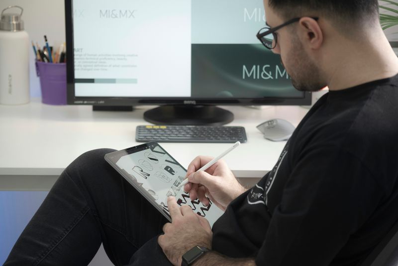 A man designing fonts and logo on his iPad.