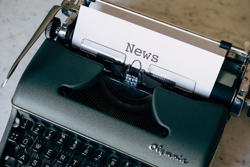 A typewriter with a reel of paper that reads 'News'