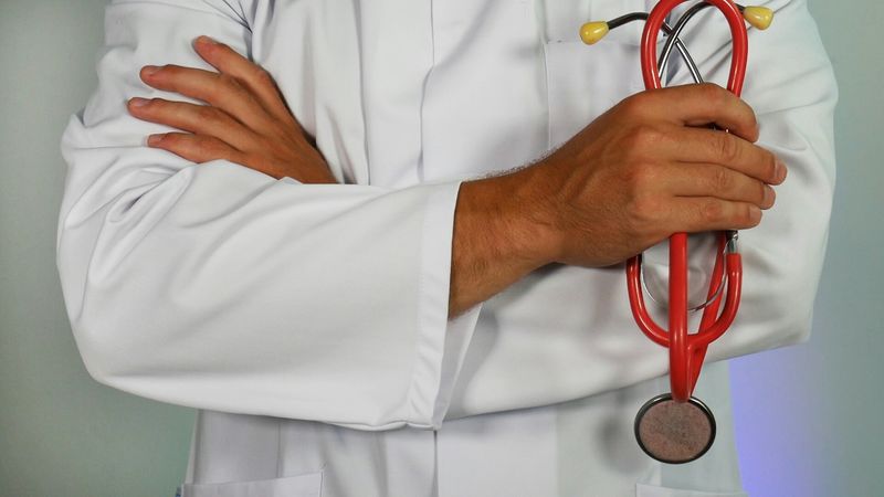 A doctor in a lab coat holding a stethoscope.