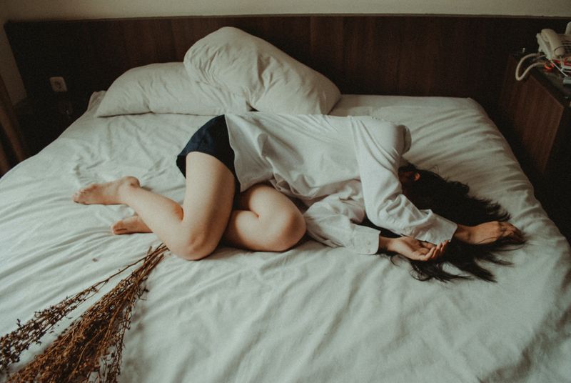 A woman experiencing the symptoms of menopause while lying in bed.