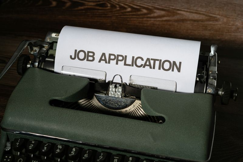 A typewriter with the words Job Application typed on paper. 