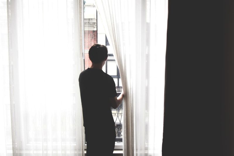 A man looking out of the window alone