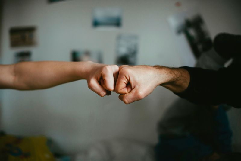 Two people giving each other a fist bump.