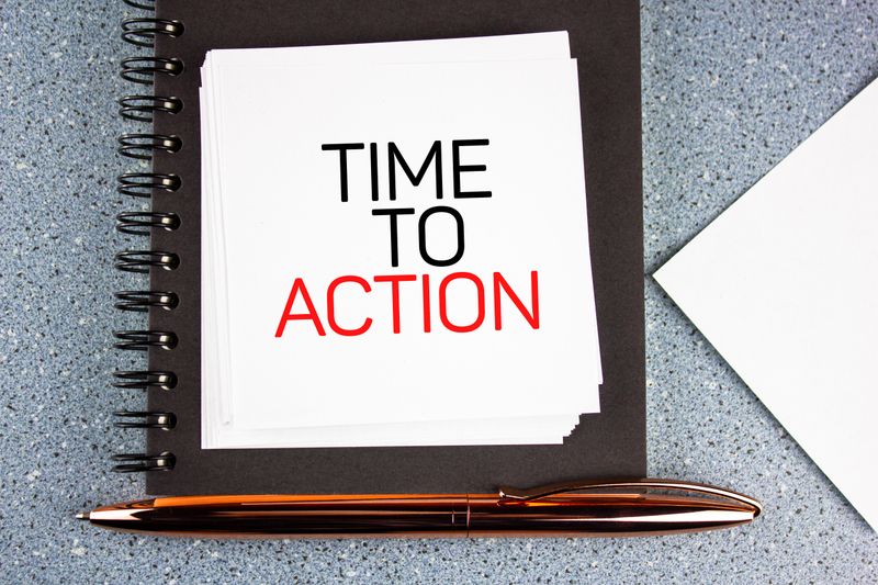 A written text on a notepad that says &apos;Time to action&apos;.