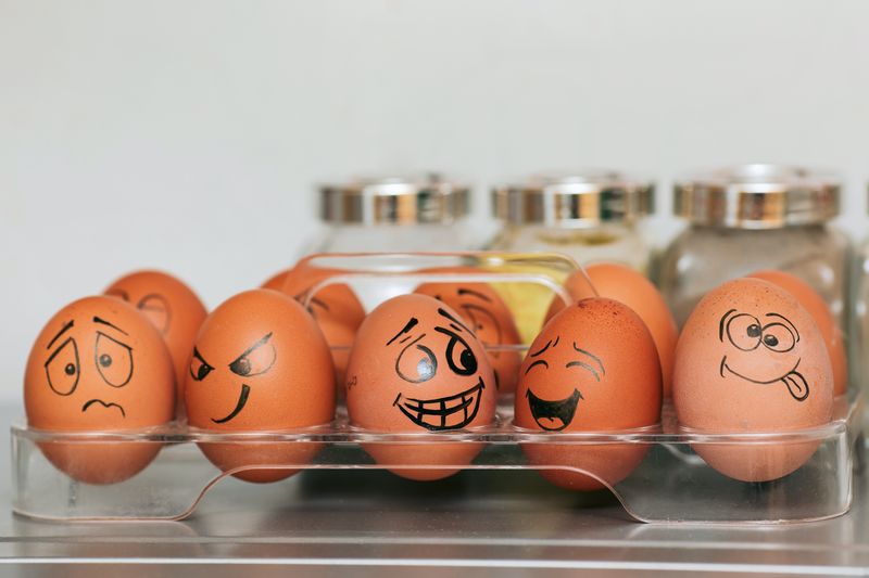 Carton of eggs with different faces representing emotions written on them.