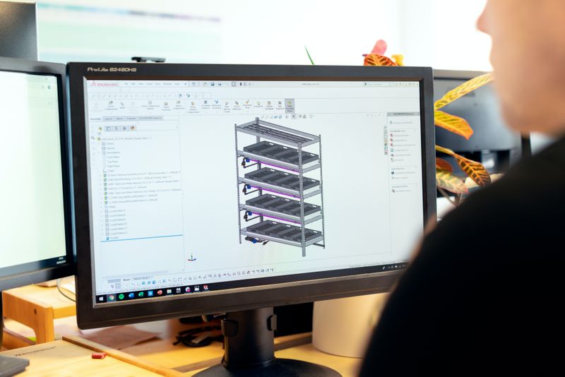 An engineer looking at a design image on a computer screen