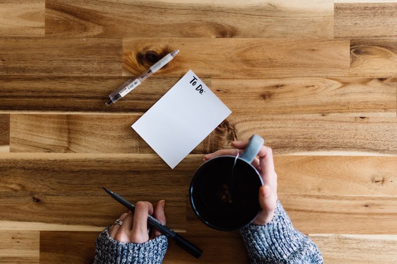 On a desk there is a pen and a piece of paper on which a girl is going to write her 