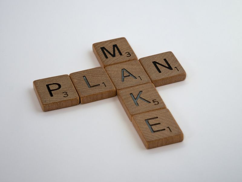 Scrabble tiles spelling two words, make and plan.