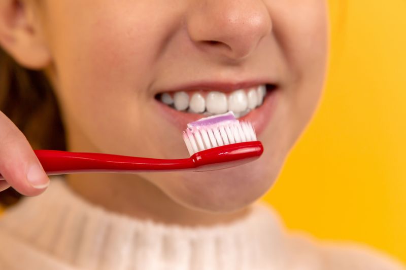 A girl smiling and holding a toothbrush