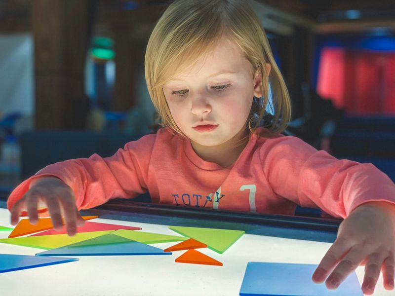 A child using multiplication games with shapes.