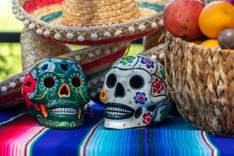 Two porcelain skulls on a table. They're painted colorfully for the Day of the Dead celebration.