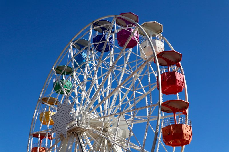 Colorful ferris wheel against a clear blue sky.