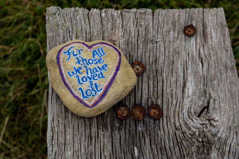 A stone with 'for all those we have loved and lost' written on it 