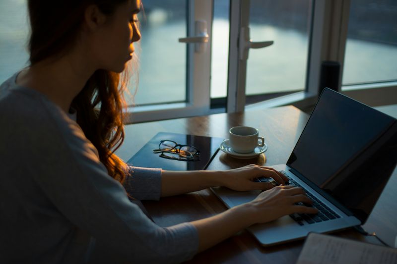 A person working on a laptop at a desk.
