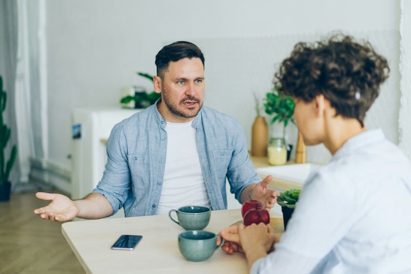 Two coworkers discussing during tea break, one is expressing his frustration, the other is engaged and not interrupting.